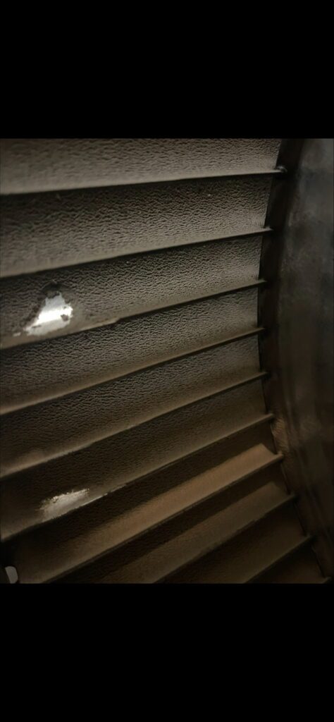 Close-up of a damaged metal turbine blade with visible holes and wear.