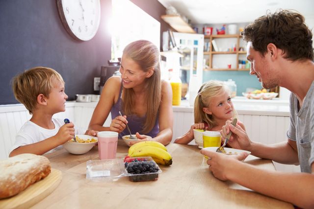 Family enjoying breakfast together around the kitchen table.